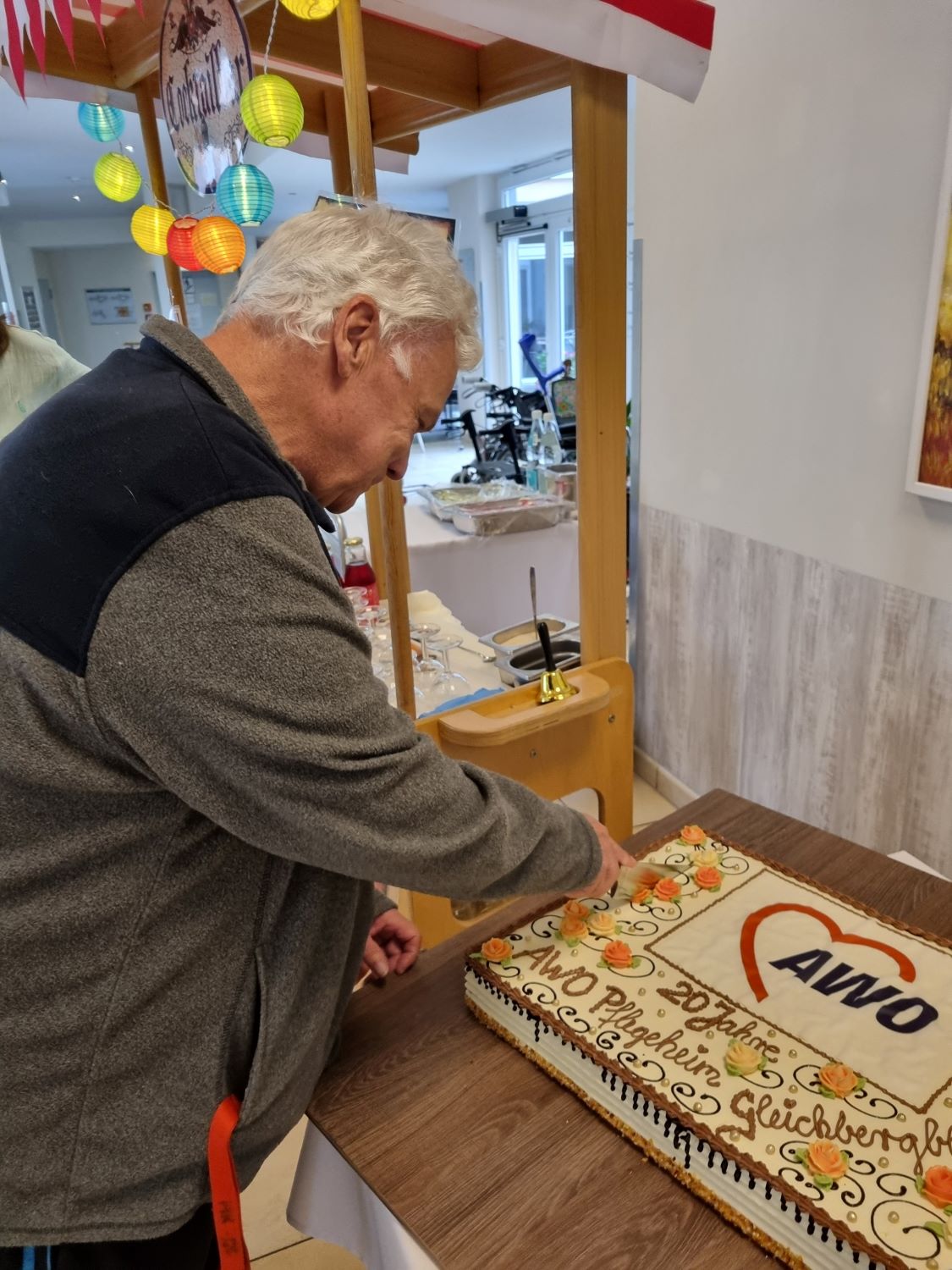 Ein Bewohner schneidet den Kuchen an